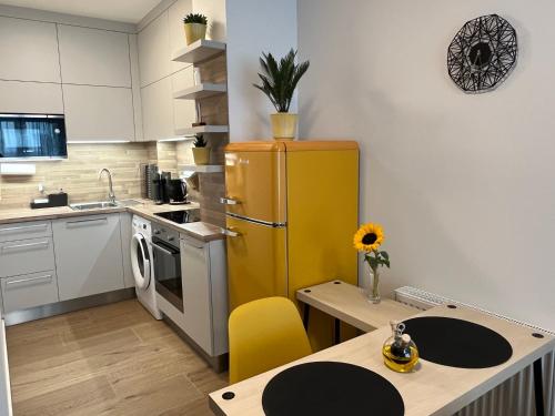 een keuken met een gele koelkast en een tafel bij Apartmán U Pelikána in Olomouc