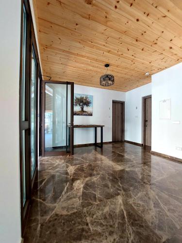 an empty room with a wooden ceiling and a table at Agros Green Valley Suites in Limassol