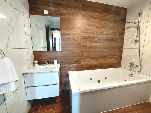 a bathroom with a tub and a sink and a mirror at Agros Green Valley Suites in Limassol