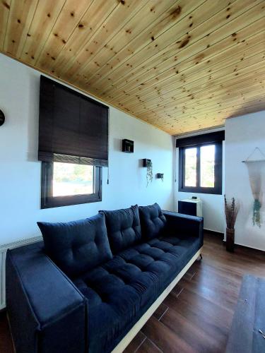 a living room with a black couch and wooden ceilings at Agros Green Valley Suites in Limassol