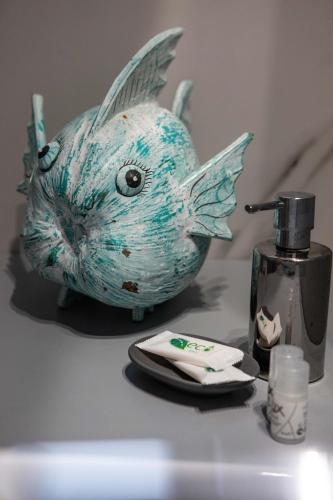 a fish head on a bathroom counter with a soap dispenser at ANGELO Cafe Hotel in Tolo