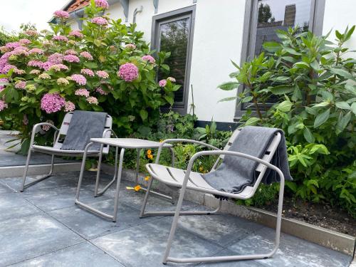 two chairs sitting on a patio with flowers at Ambiance in Hollum