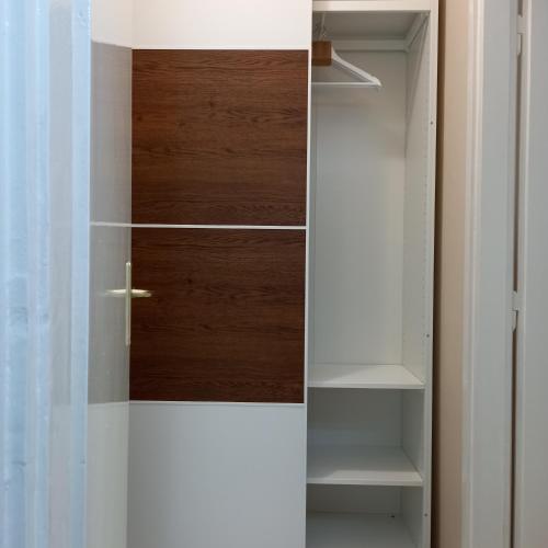 a closet with a wooden door and shelves at Rivijera in Belgrade