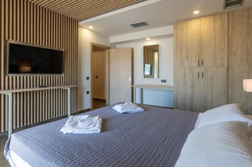 a bedroom with a bed with two towels on it at Paradise Resort in Finikounta