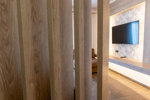 a room with a sliding door with a tv on a wall at Paradise Resort in Finikounta