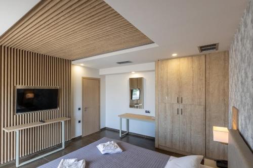 a room with a bed and a tv on a wall at Paradise Resort in Finikounta