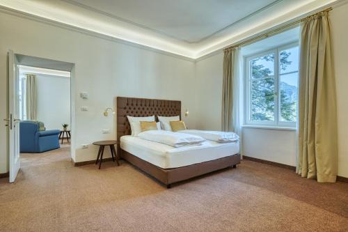 a bedroom with a bed and a large window at Villa Tell rooms and suites in Merano