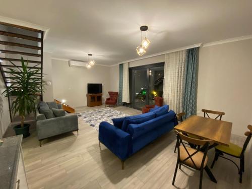 Sky Villa Hisar في طرابزون: غرفة معيشة مع أريكة زرقاء وطاولة
