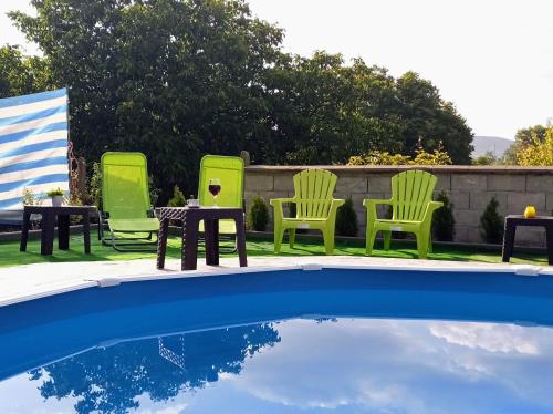 a group of chairs and a table next to a pool at Guest House 51 in Kranevo