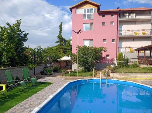 a house with a swimming pool in front of a building at Guest House 51 in Kranevo