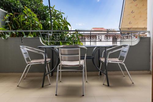 a table and chairs on a balcony with plants at Angelo Apartments Tolo in Tolo