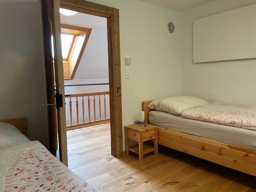 a bedroom with two beds and a door to a balcony at Landhaus Waisenegg 