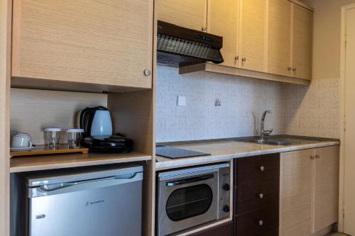 a small kitchen with a sink and a microwave at Paradise Resort in Finikounta
