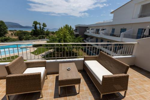 a balcony with a couch and chairs and a pool at Paradise Resort in Finikounta