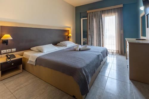 a bedroom with a large bed with two stuffed animals on it at Paradise Resort in Finikounta