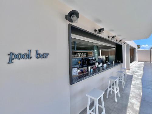 a bar on the side of a building with stools at Paradise Resort in Finikounta
