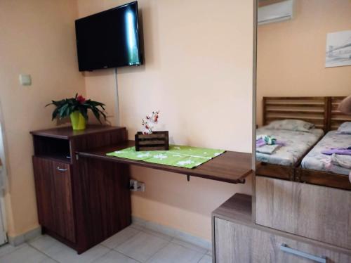 a room with a desk and a bed and a tv at Guest House 51 in Kranevo
