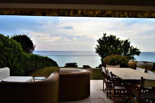 a patio with a table and chairs and the ocean at Elenos Villa in Possidi