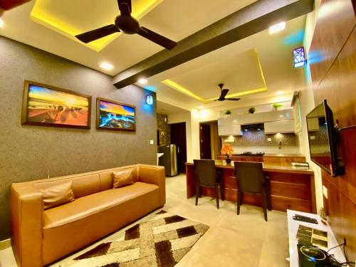 een woonkamer met een bank en een bar bij Green Royale Living Spaces - Luxury Serviced Apartments in Trivandrum