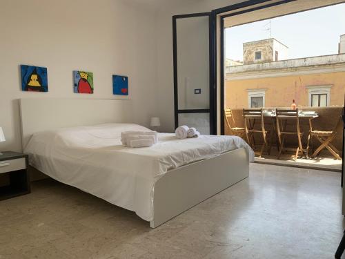a bedroom with a white bed and a large window at Nardò Kiss in Nardò
