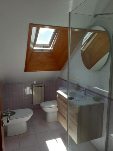 uma casa de banho com um WC, um lavatório e uma janela em Atico con terraza y piscina comunitaria em Ribadeo