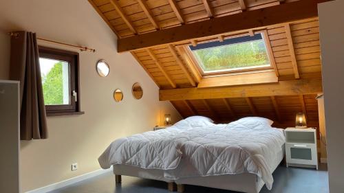 a bedroom with a large bed with a wooden ceiling at Gîte La Borbotte in Malmedy