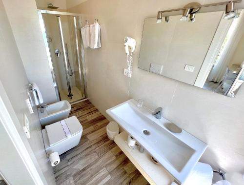 a bathroom with a sink and a toilet and a mirror at Hotel Boncardo in Finale Ligure