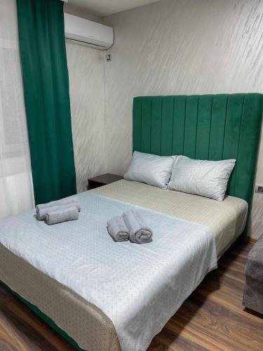 a bedroom with a bed with two slippers on it at Pink House Apartments in Jagodina