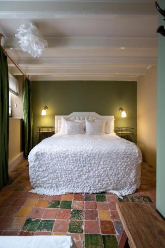 a bedroom with a large white bed in a room at Sterlogies Cityhouse Madame Agaath in Leeuwarden