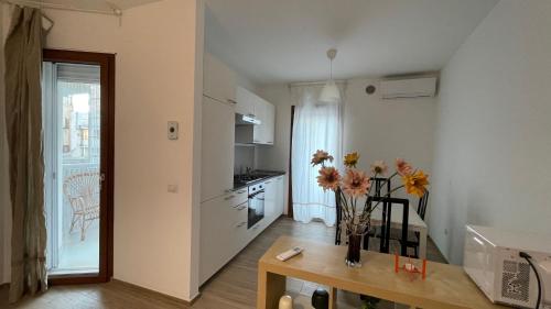 a kitchen with a vase of flowers on a table at Central Modern Apartment Bari in Bari