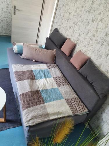 eine Couch mit Kissen und eine Decke drauf in der Unterkunft Übernachtung an der A2 in Braunschweig