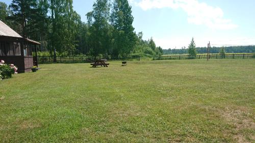 una mesa de picnic en medio de un campo en Pirmie Zaļmeži, en Jūrkalne