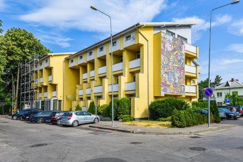 a yellow building with a large mural on the side of it at Apartamentai Palangos centre in Palanga
