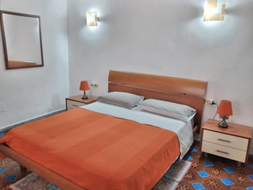 a bedroom with a bed with two night stands and two lamps at Casa Vacanza Dante in Nurachi