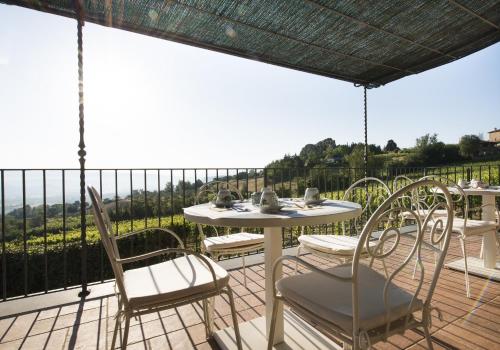 a patio with a table and chairs on a balcony at Altarocca Wine Resort Adults Only in Orvieto