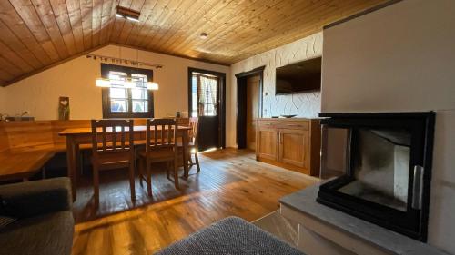 a kitchen and dining room with a table and a fireplace at STARLING Apartment Nassfeld in Hermagor
