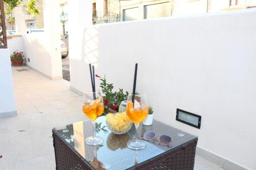 a table with two wine glasses and fruit on it at Sa Domm'e Galleria in Baunei