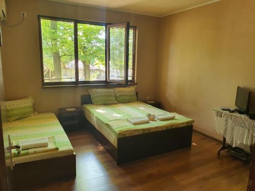 1 dormitorio con 2 camas y ventana en Holiday Home Maarata en Krushuna