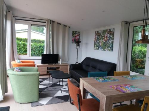 sala de estar con sofá y mesa en Luxe bungalow op rustig vakantiepark., en Dronrijp