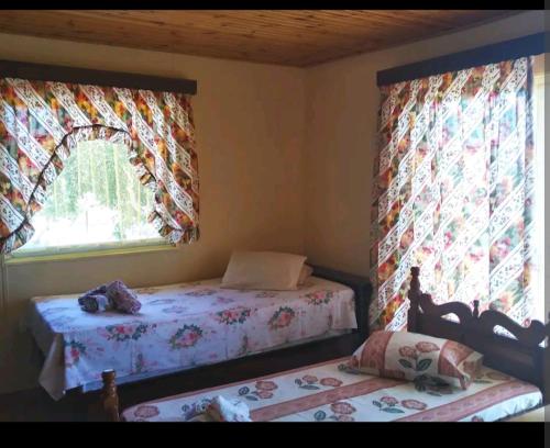 a bedroom with two beds and two windows at MAGNIFICENT SEA VIEW HOUSE in Methana