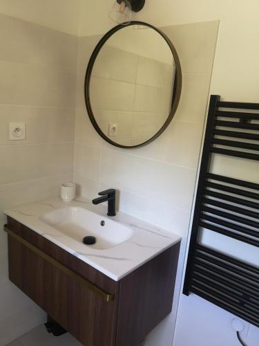 une salle de bain avec un lavabo et un miroir au mur dans l'établissement Studio au calme vue sur garlaban, à Roquevaire