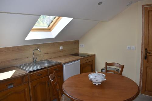 a kitchen with a table and a sink and a window at LA DEMEURE DE LA JUINE in Morigny-Champigny