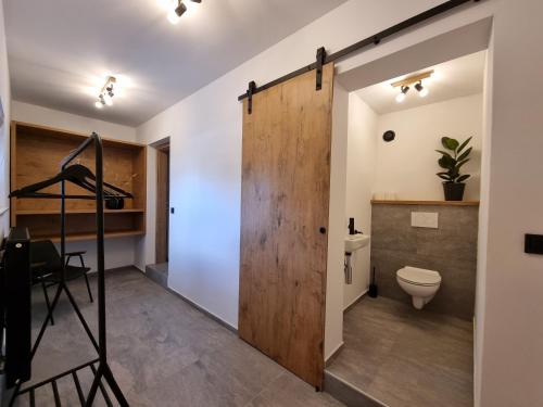 a bathroom with a wooden door and a toilet at Bistro & Rooms pri Karlu - ex Hiša Budja in Maribor