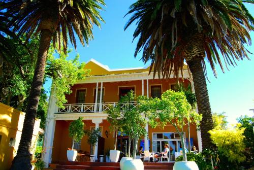 a house with palm trees in front of it at Ashanti Lodge Backpackers in Cape Town