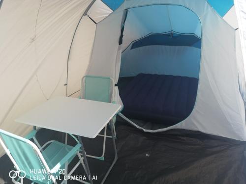 une tente avec une table et des chaises à l'intérieur dans l'établissement Tente chez l'habitant, à Saint-Jean-de-Monts