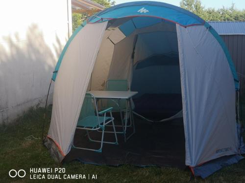 une tente avec une table et deux chaises dans l'établissement Tente chez l'habitant, à Saint-Jean-de-Monts