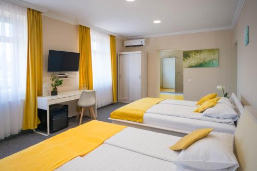 a hotel room with two beds and a desk at Seva Hotel Health Club in Campina
