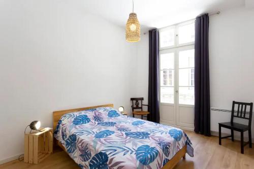 a bedroom with a bed and a large window at Magnifique 2 pièces - Plein centre - Tram 1 min in Montpellier