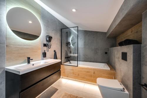 a bathroom with a tub and a sink and a toilet at Loft House Double Apartament z ogródkiem in Rybnik