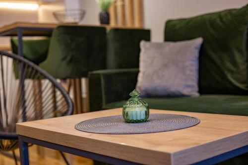a green vase sitting on top of a wooden table at Titova Vila Zlatibor in Zlatibor